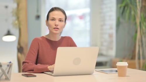 Woman Working at Laptop Gives Thumbs Up
