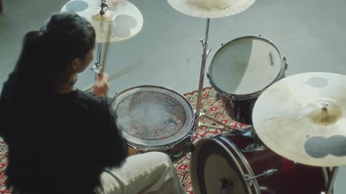 Woman Playing Music on Drum Kit in Studio