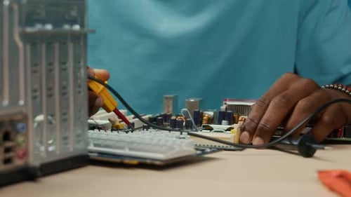 Unbekannter Spezialist, der die Hauptplatine eines Computers mit einem Lötkolben repariert