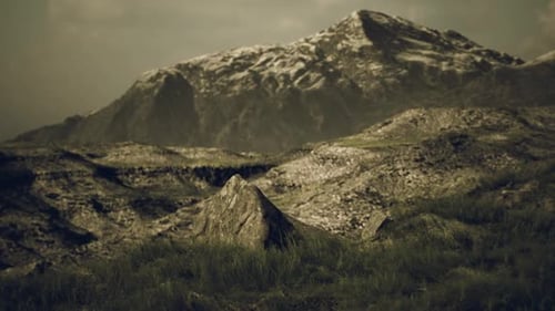 A Rugged Mountain Landscape with Rocky Terrain and Distant Peaks in Twilight