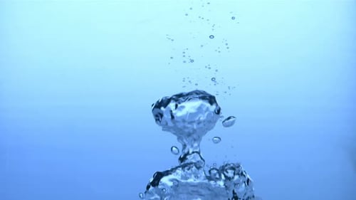 Ice Cube Plunging into Water Bubbles Underwater