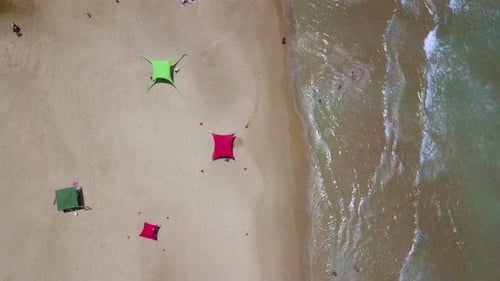 Summer day at a local beach with people relaxing under umbrellas
