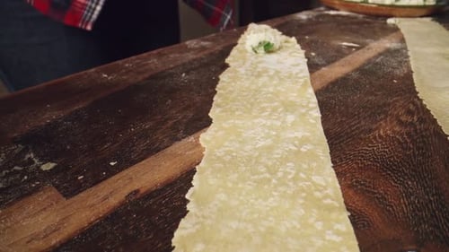 Man Preparing Cheese Filling for Pasta on Wooden Board