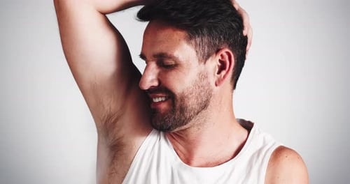 Smiling Man in Tank Top Raises Arm