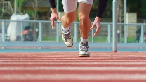 Junger Mann macht einen Bahnrunning-Start