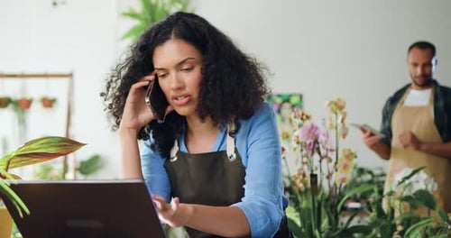 Young Woman Using Laptop and Phone in Flower Shop