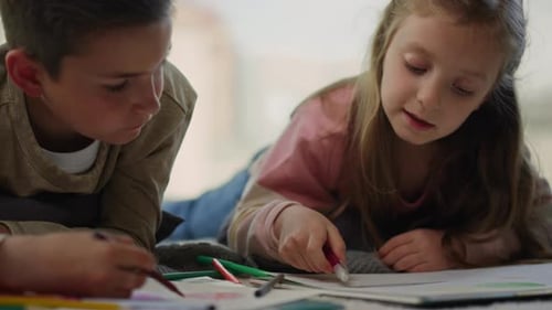 Children Drawing Together on Floor Indoors