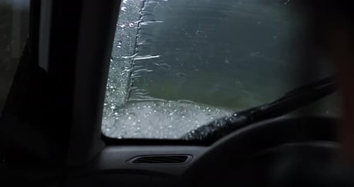 Blick durch das nasse Autofenster bei regnerischem Wetter