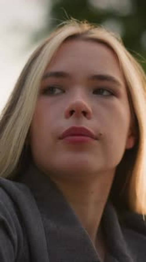 Contemplative Woman with Blonde Hair Looking Away Outside