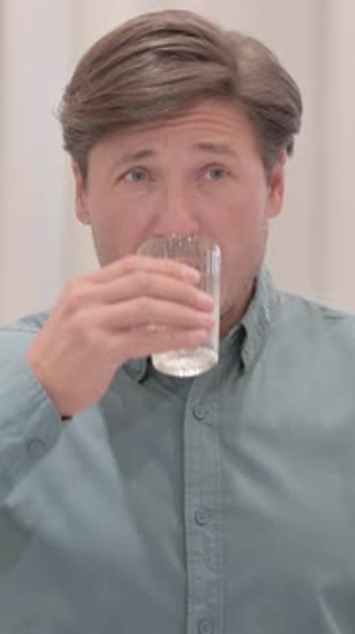 Man drinks water from glass close up portrait