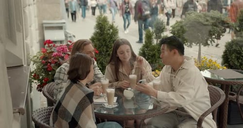 Group of Friends Talk Over Coffee at Outdoor Cafe