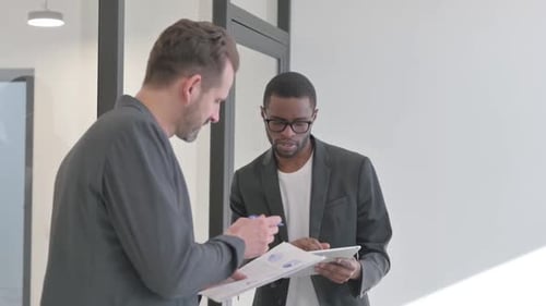 African Entrepreneur Discussing Work with Employee, Standing in Office