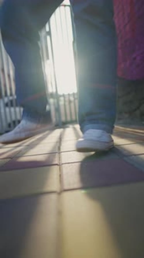 Male Legs in White Sneakers Dance Hip Hop on City Street in Sunlight