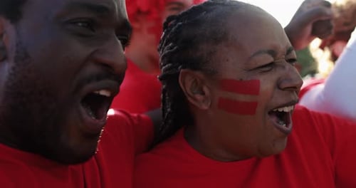 Enthusiastic fans cheer and celebrate outdoors