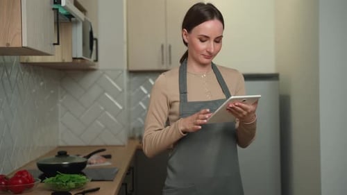 Woman Uses Tablet in Bright Modern Kitchen