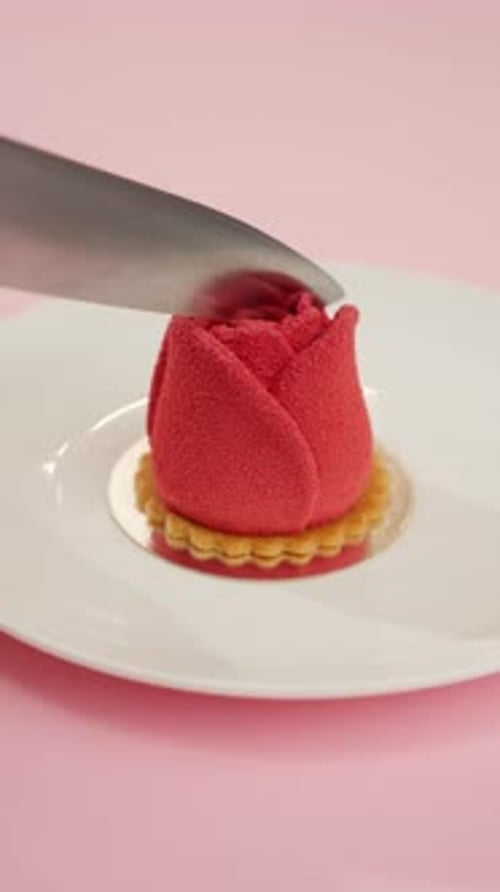 Cutting a Rose Cake on Pink Background