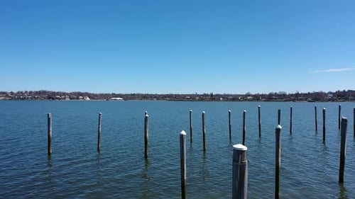 A low angle shot over the calm waters of Little Neck Bay. The drone camera dolly in towards deeper w