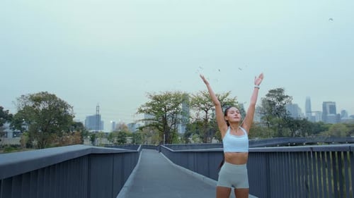 Young fitness woman in sportswear exercising in city park