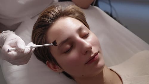 Young Woman Receives Facial Treatment at Spa