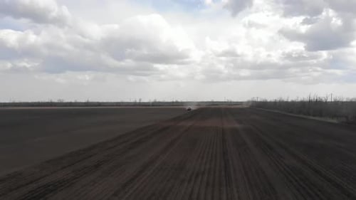Blue tractor working on the field in Odessa in Ukraine during planting sunflower