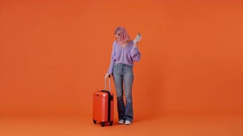 Excited Woman Holding Tickets and Red Suitcase in Studio