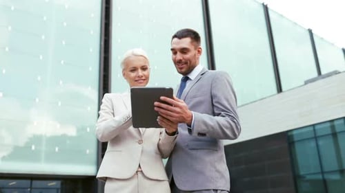 Smiling business partners collaborate with tablet technology on a city street