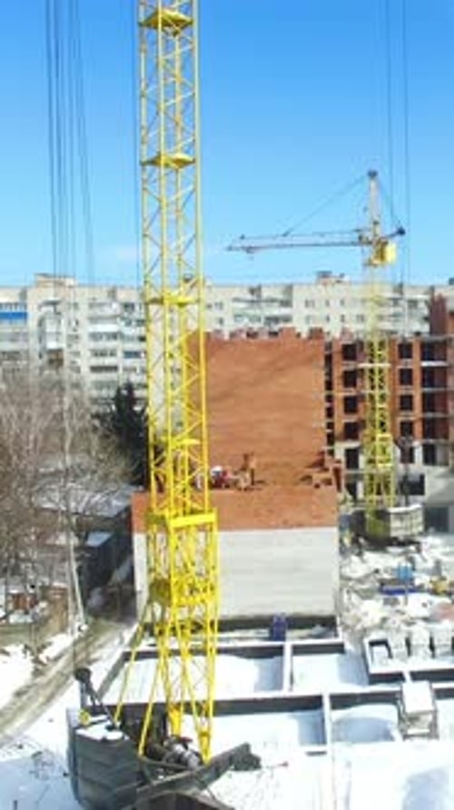 Elevación de grúas y actividad de construcción. Vista aérea del sitio de construcción de grúas y edificios
