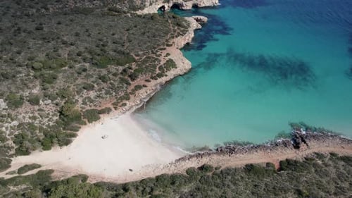 Aerial view of serene beach bay with azure waters, Spain.