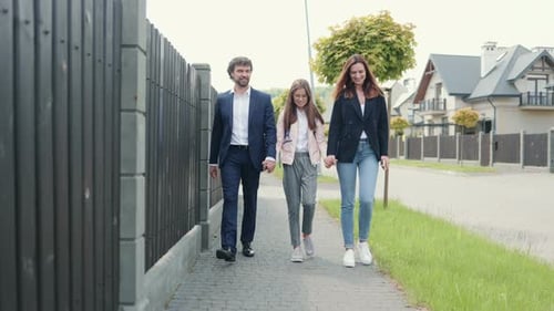Caucasian Beautiful Family Mother Father and Their Cute Happy Daughter Walking From School After