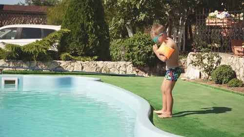 Little Boy in Armbands About to Jump Into the Pool Slowmotion Video
