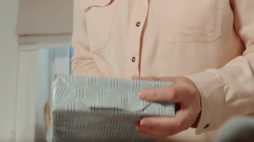 Woman Wrapping a Present with Decorative Paper