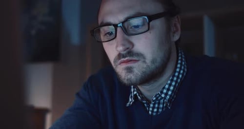 A Focused and Driven Professional Working Late Hours at Their Computer Late at Night
