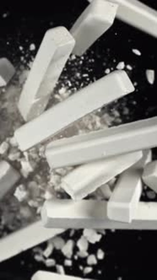 School Chalk Flies Up and Falls Down on a Black Background Filmed on a Highspeed Camera at 1000 Fps
