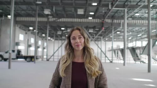 Confident Woman Owner in Empty Warehouse