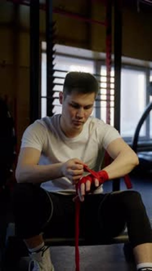 Atleta concentrado que se envuelve las manos antes del entrenamiento