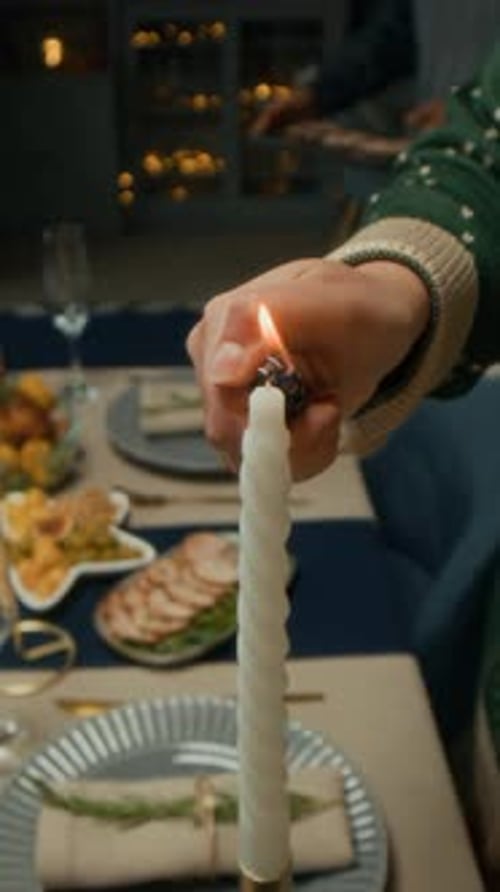 Vertical of Anonymous Person Lighting Candle on Christmas Holiday Dinner Table