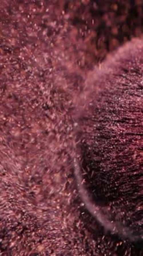 Vertical Screen Makeup Brushes Touch Each Other on Dark Background and Small Particles of Cosmetics