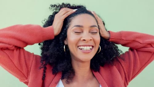Woman Laughing and Touching Curly Hair