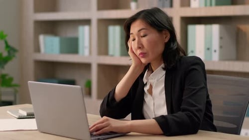 Focused Woman Working on Laptop in Quiet Office