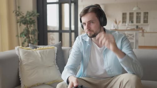 Man Playing Video Game at Home on Couch