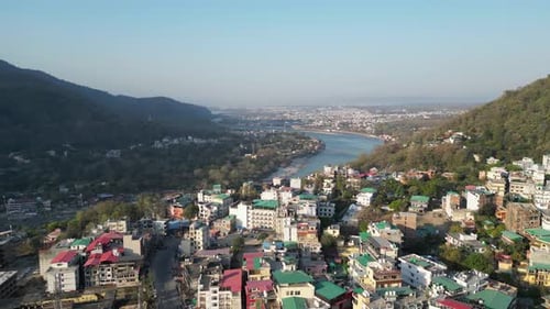 beautiful buildings on hills and Ganga river going in Rishikesh drone view in india