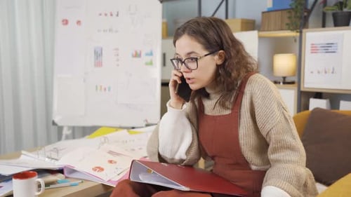 Frustrated Woman Talking on Cell Phone at Desk