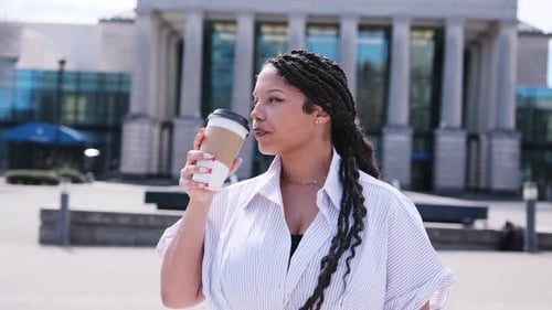 African American Businesswoman Drinking Coffee Outside an Office Building