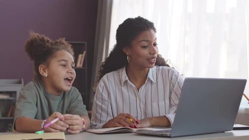 Woman and Child Learning Together on Laptop at Home