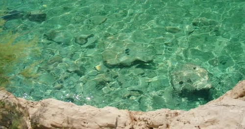 Clear turquoise sea water with underwater rocks on coast in summer Croatia