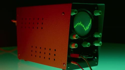 Osciloscópio vintage com forma de onda verde sob iluminação vermelha