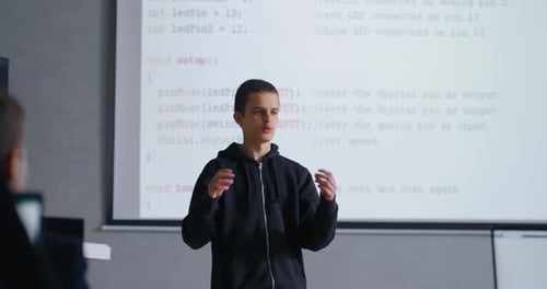 Portrait Of Smart Teen Boy Speaking In Front Of Classmates In Modern Classroom Presenting Project