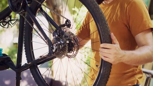 Man Repairing Bicycle Tire Outdoors in the Daytime
