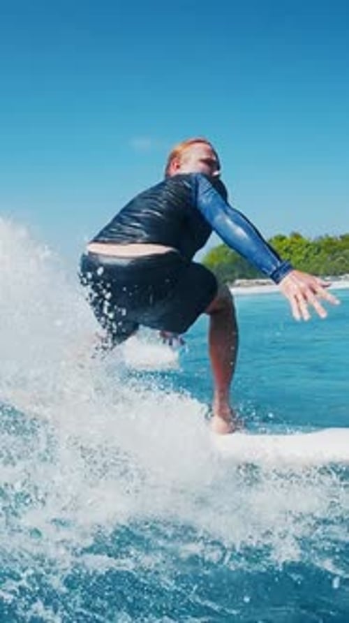 Surfer Rides the Wave in the Ocean in the Maldives