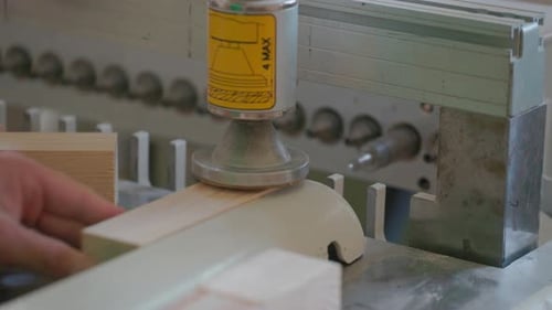 A man works with wood in a workshop. Working with wooden blanks. A man drills